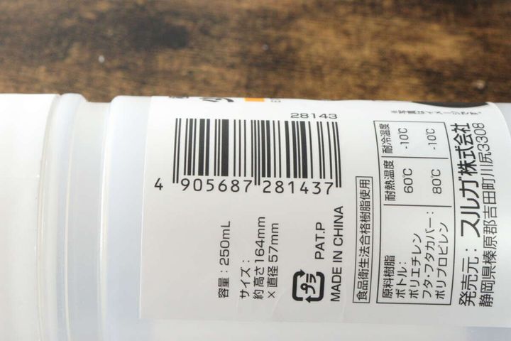 白い極細オイルボトルの裏面に貼られたバーコードと商品情報が写っている