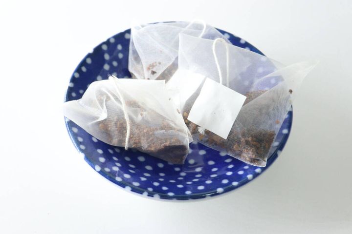 青い水玉模様の小皿に白いティーバッグが3つ並べられている