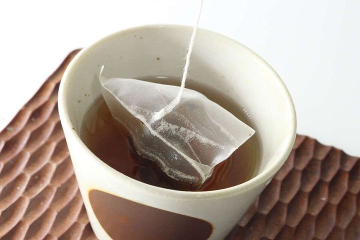 白い湯呑み茶碗にティーバッグが浸されお茶を淹れている様子