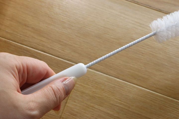 女性の手がパイプクリーナーの持ち手部分を握っている
