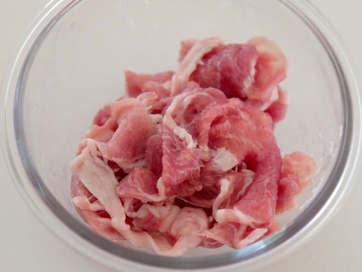 透明なガラスボウルに入った豚こま切れ肉のアップ