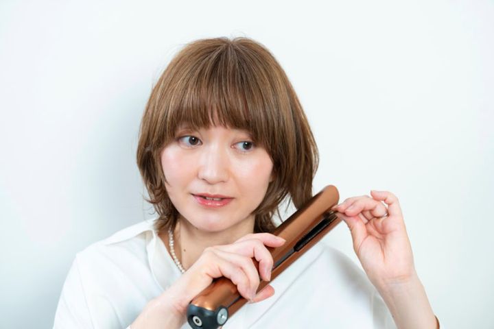 ヘアアイロンで顔まわりや表面の毛を内巻きに、毛先は外ハネに