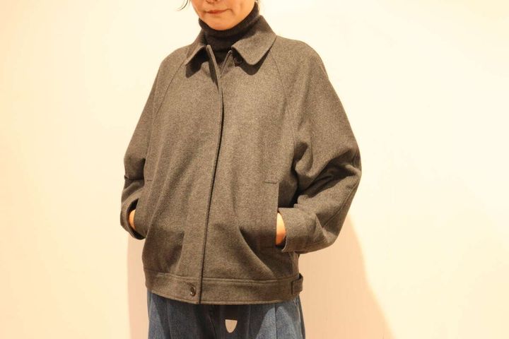 グレーのハリントンジャケットを着た女性がポケットに手を入れている