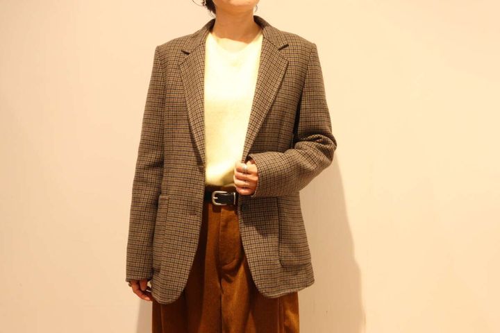 ブラウンのチェック柄テーラードジャケットを着た女性の全身