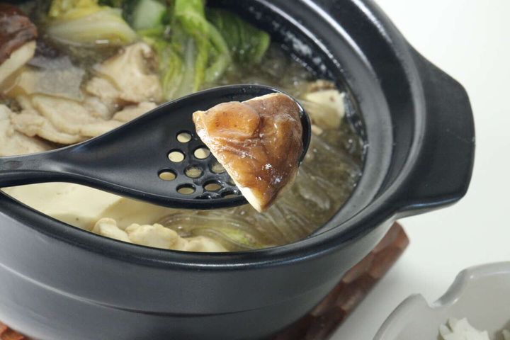 鍋から穴あきレンゲでしいたけをすくっている様子