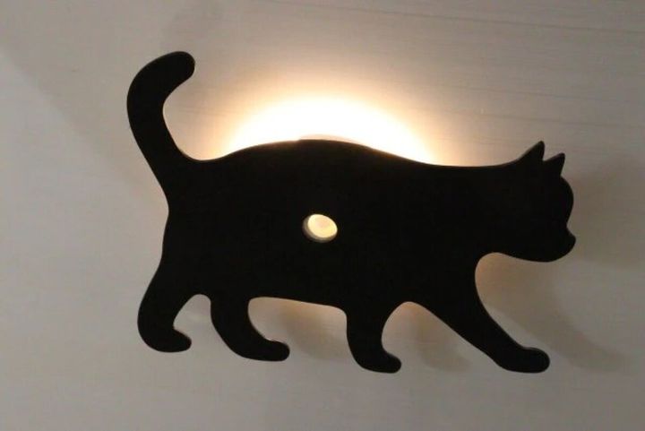 壁に設置された猫のシルエットライトが点灯している
