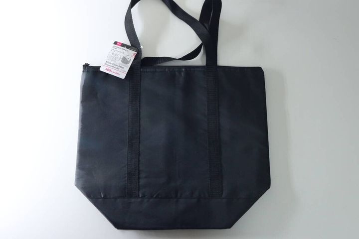黒いアルミトートバッグが平置きされており、商品タグが付いている