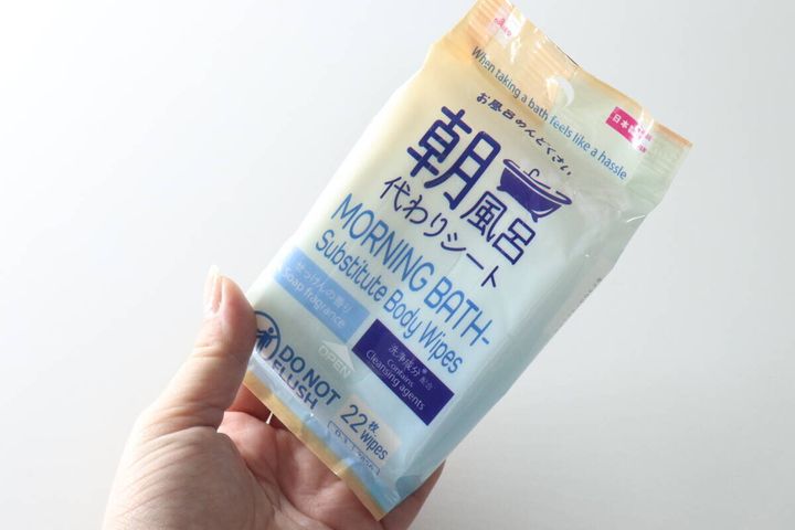 女性が手に持った「お風呂代わりシート 朝」のパッケージ