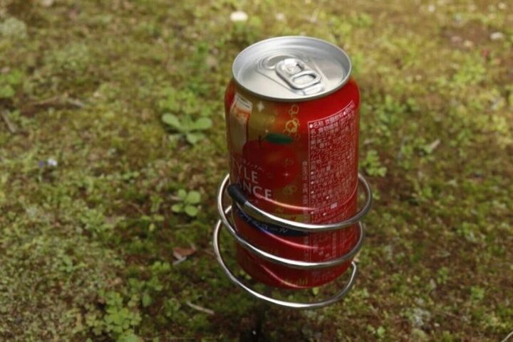 地面に刺したドリンクホルダーに赤い缶飲料が置かれている