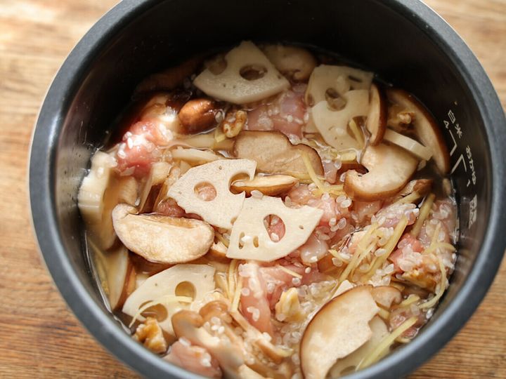 炊飯器の内釜に水が加えられ、米と具材が浸っている状態の俯瞰。