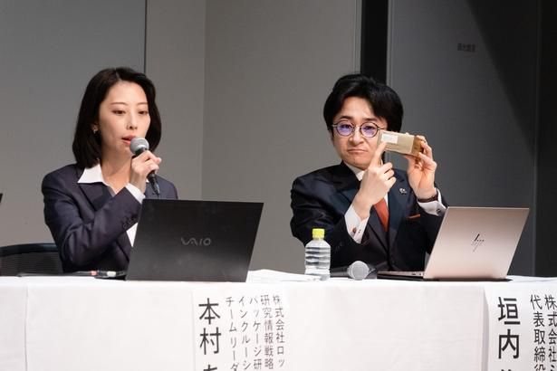 本村さんが仕組みを説明する横で、製品を手に取り「ココヨム」の表示場所を指で示す垣内社長