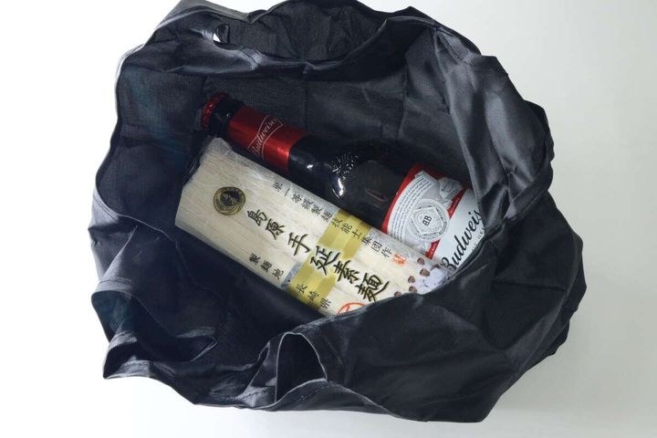 広げたエコバッグにそうめんと瓶ビールを入れた様子