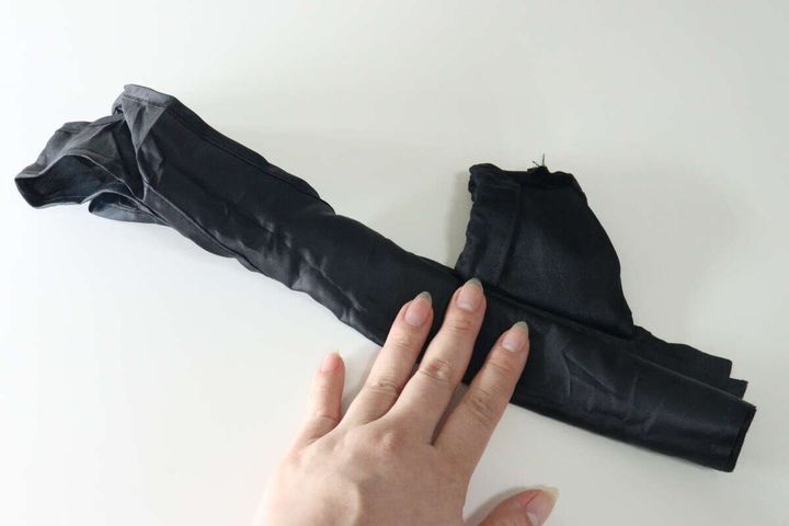 女性がエコバッグを細長く折りたたんでいる工程