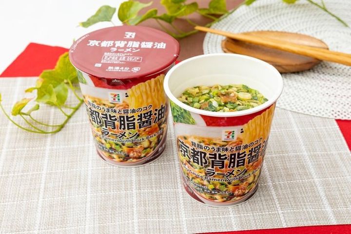 赤い蓋のカップ麺が2つ、一つは蓋が閉まり、もう一つはネギと具材が見える