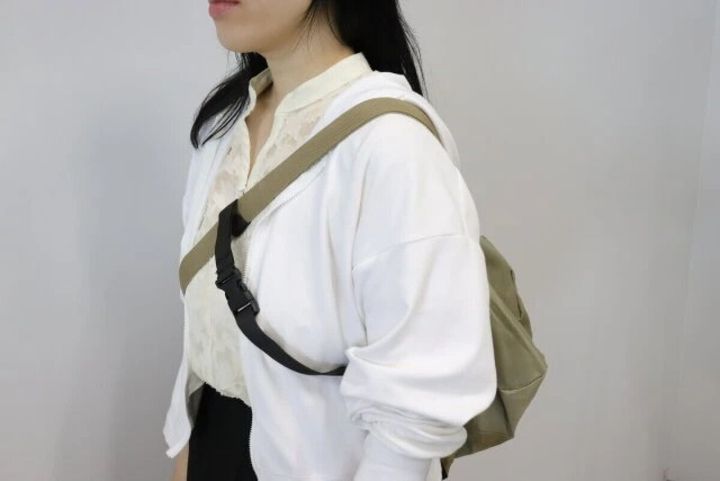 女性がショルダーバッグを斜め掛けし、クロスストラップを装着している