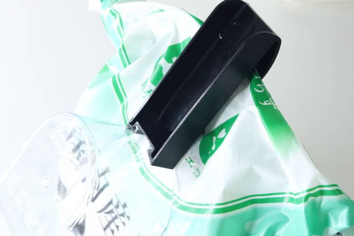 セリアの計量カップのクリップで米袋を挟んでいる様子