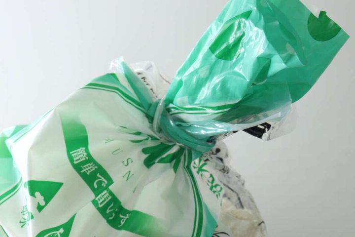 輪ゴムで縛られた緑色の米袋の口元