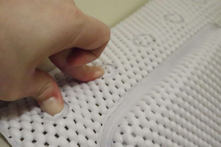 浴槽マットの吸盤を指で強く押して取り付け方を説明