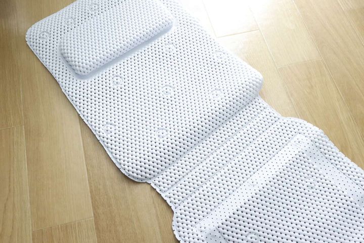 広げた状態の白い浴槽内滑り止めマットと枕
