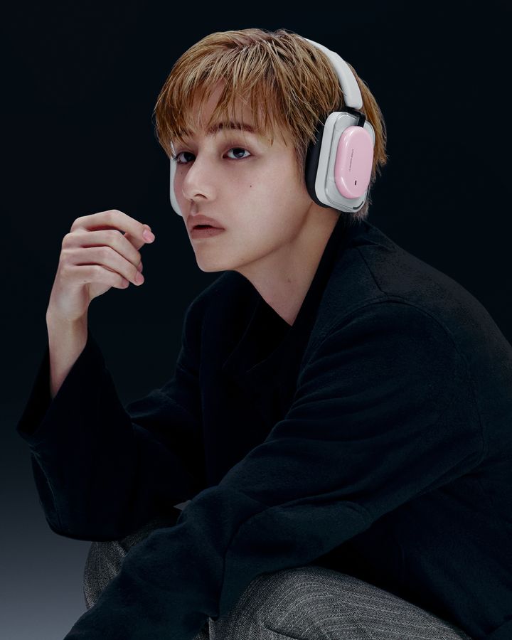 黒い服で頬に手を添え、Headphone (1) Proを着けてポーズをとるテテ