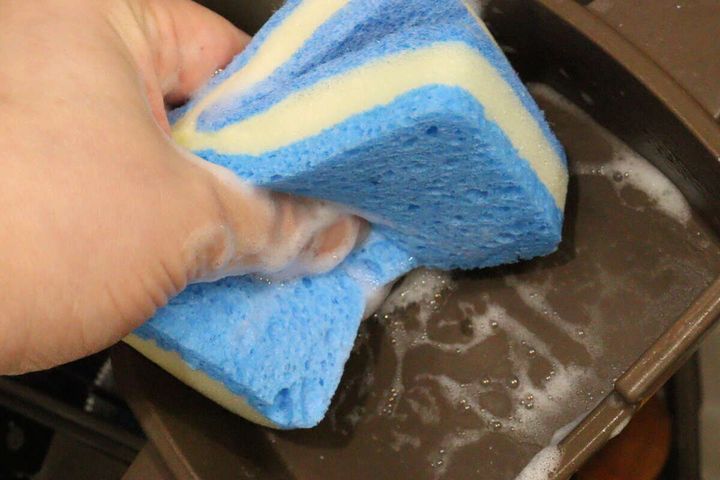 泡立ったスポンジでフライパンの縁を洗っている様子