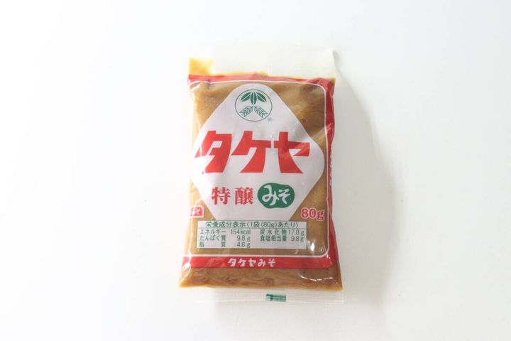白い背景に置かれたタケヤ特醸みそ80gパックの正面