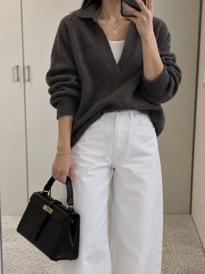 白いバギーバレルレッグジーンズとブラウンニットを着た女性