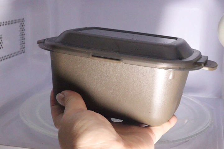 レンジ調理マルチクッカー中を電子レンジに入れている手元