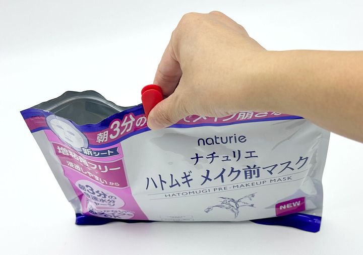 赤いスライダーでフェイスマスクのチャック袋を閉じる手元