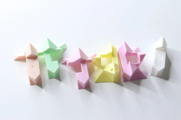分解されたパステルカラーの星形パズルキーホルダーのパーツが6つ並べられている
