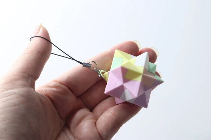 手のひらに乗せられたパステルカラーの星形パズルキーホルダー