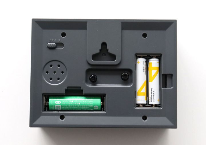 目覚まし時計の裏側にある電池ボックスと壁掛け用の穴