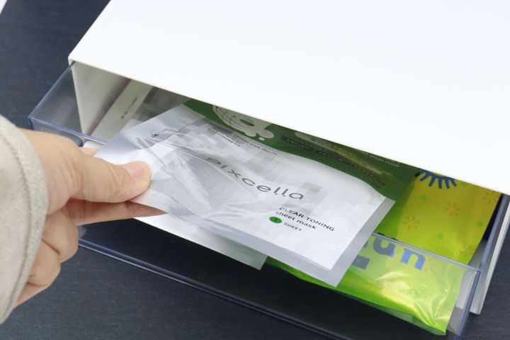 透明な引き出しにシートマスクを収納する手元