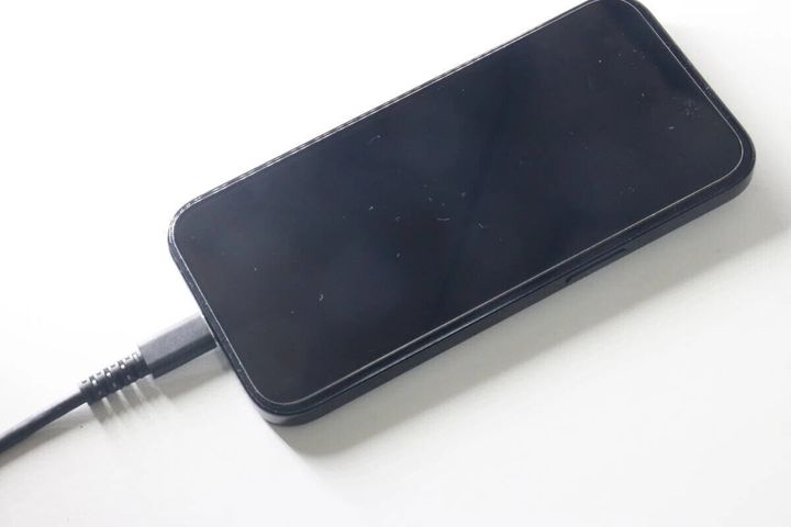 黒いスマートフォンにダイソーのUSB Type-Cケーブルを接続して充電している様子