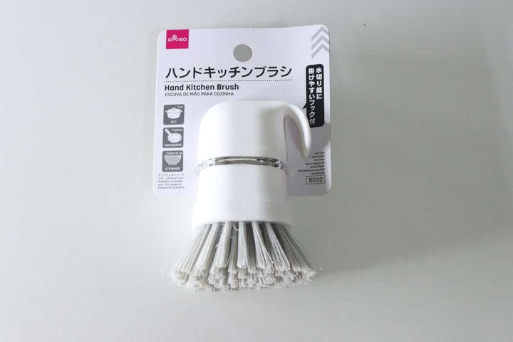 白い背景に置かれた、パッケージに入った白いハンドキッチンブラシ