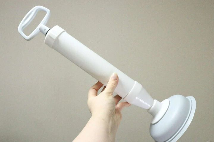 女性が白いレバータイプのパイプクリーナーを手に持っている