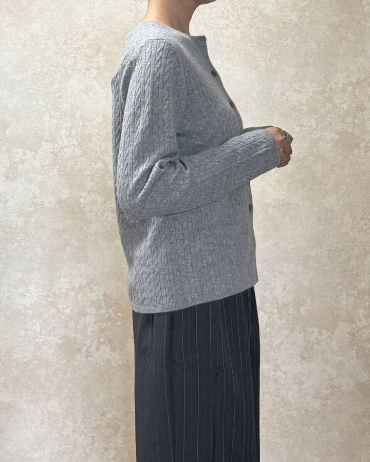 グレーカーディガンを着用した女性が横を向いている