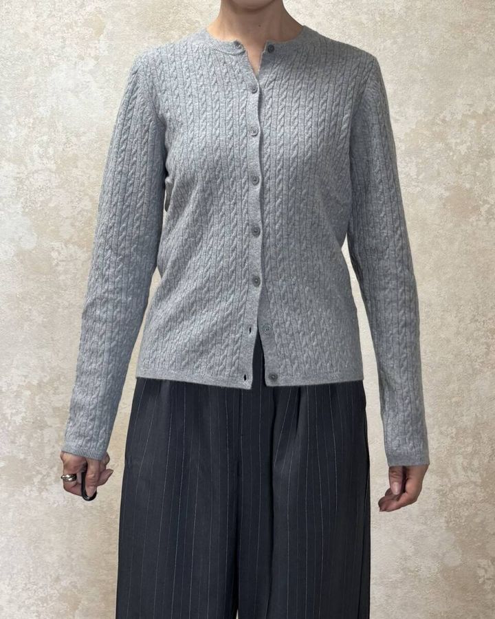グレーカーディガンを着用した女性が正面を向いている