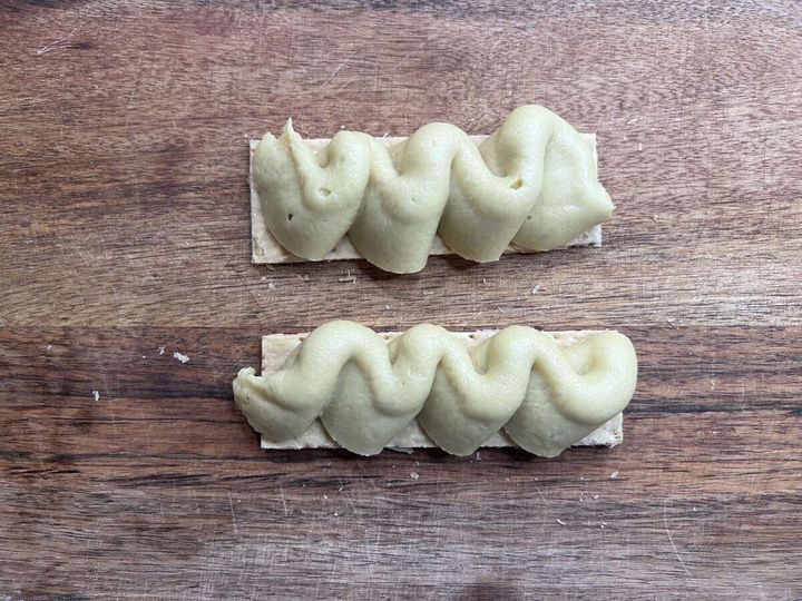 木目のまな板の上に、パイシート2枚に焼き芋クリームが波状に絞り出されている