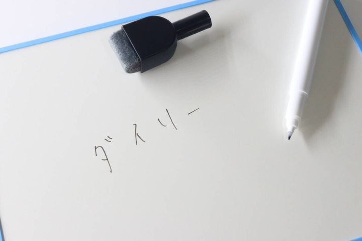 ホワイトボードに書かれた文字とマーカー、イレーザー