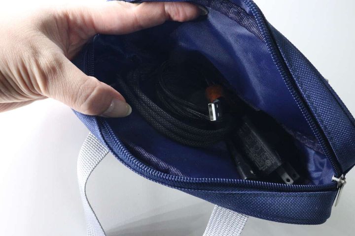 ペンケースのファスナーを開けガジェットを入れている