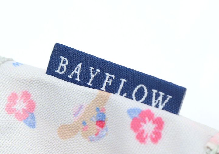 カップスリーブのサイドに縫い付けられた「BAYFLOW」の紺色タグのアップ