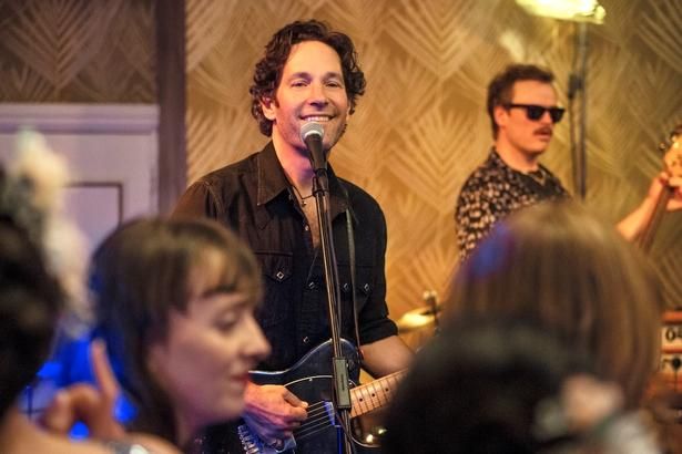 【写真を見る】ポール・ラッドが演じるのはシンガーソングライターの夢を抱くウェディング・シンガーのリック [c] 2026 Indigo Dreams, LLC / Rubicon Films LTD. ALL RIGHTS RESERVED
