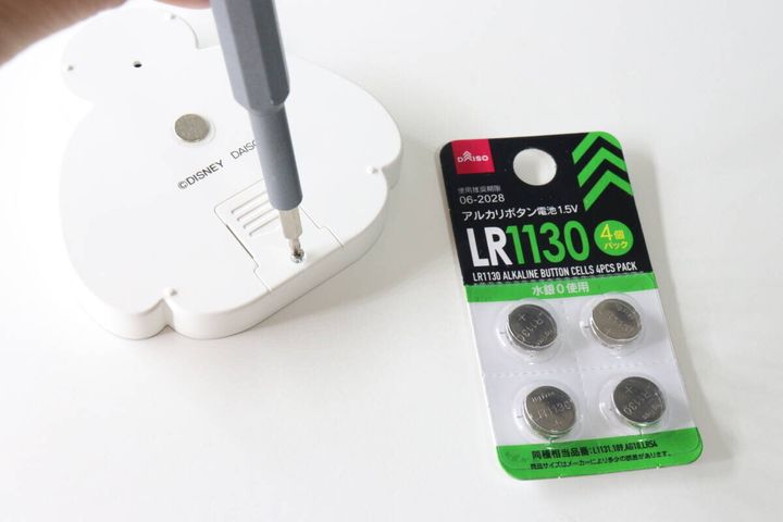 ドライバーでタイマーの電池カバーを開けボタン電池を置いている