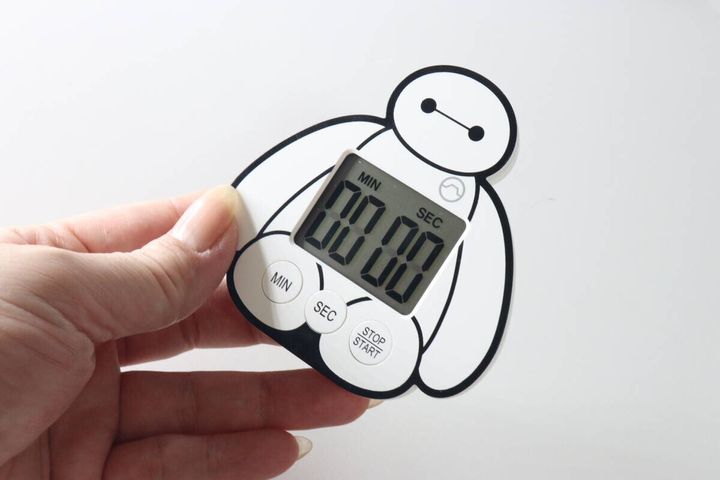 女性がベイマックスのキッチンタイマーを手に持っている