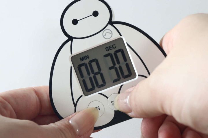 女性がベイマックスタイマーのSECボタンを押して時間を設定