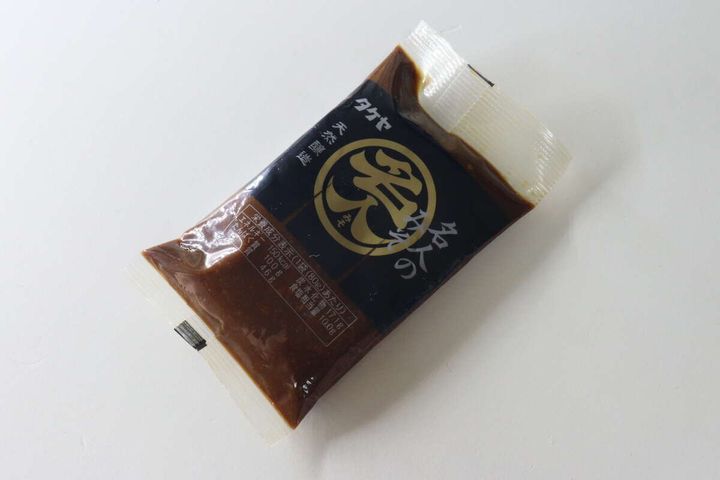 白い背景に斜めに置かれたタケヤ名人のみそ80gのパッケージ