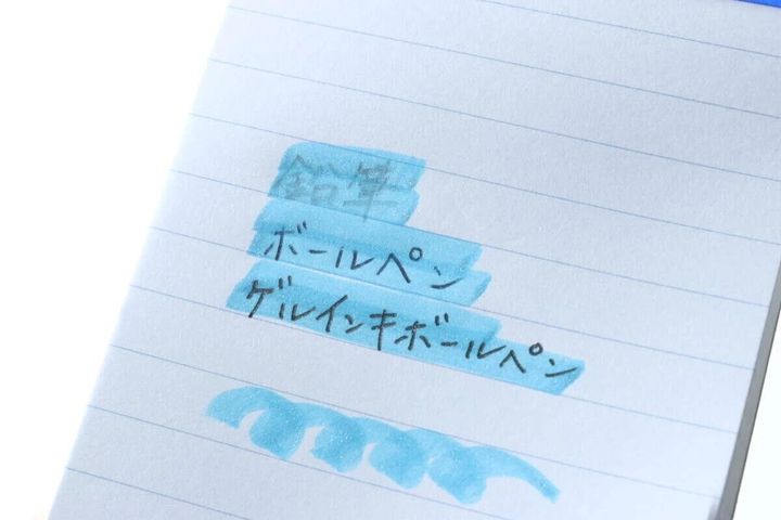 ノートの文字に水色蛍光ペンでラインを引いている