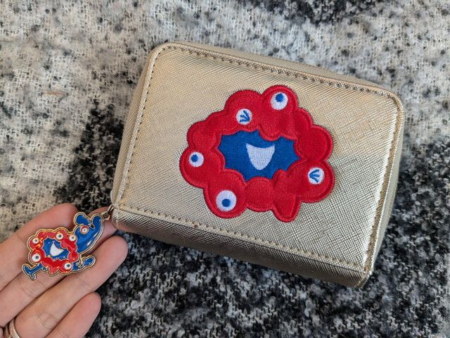赤×青ミャクミャクの刺しゅうとファスナーチャームのアップ
