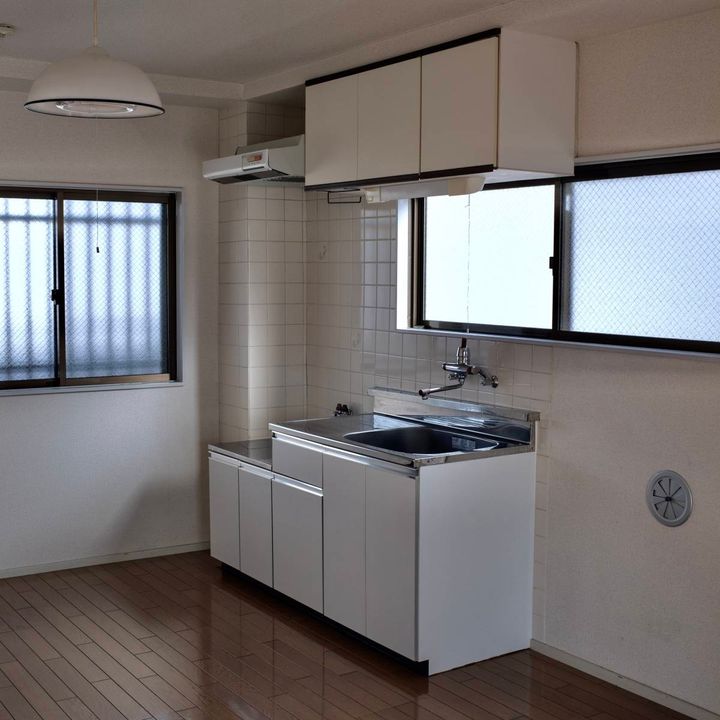 真っ白な殺風景な部屋の内装。窓があるキッチン。